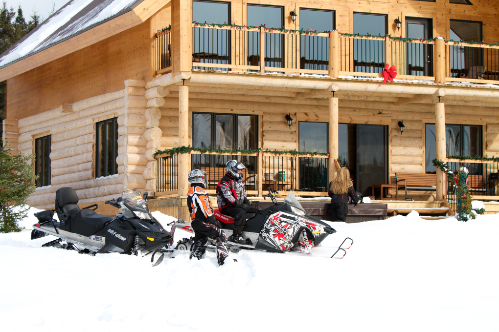 Motoneige devant un chalet en bois rond