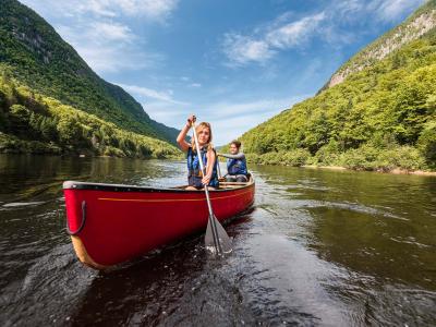 Deux jeunes femmes font du canot dans la rivière au creux de la vallée, dans le Parc national de la Jacques-Cartier.