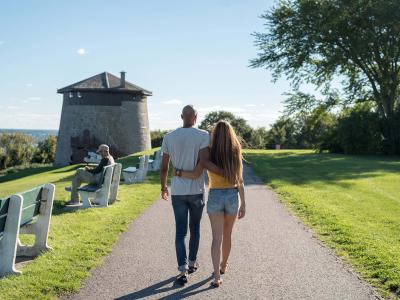 Couple amoureux marchant sur les plaines d'Abraham, en direction de la Tour Martello 1, en été.
