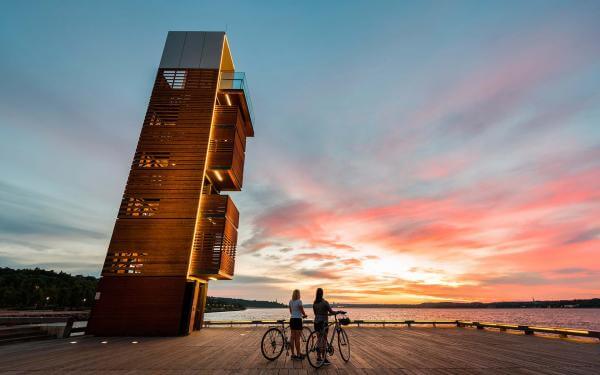 Deux cyclistes contemplent le lever du soleil sur la promenade Samuel-De Champlain, à partir du Quai des Cageux.