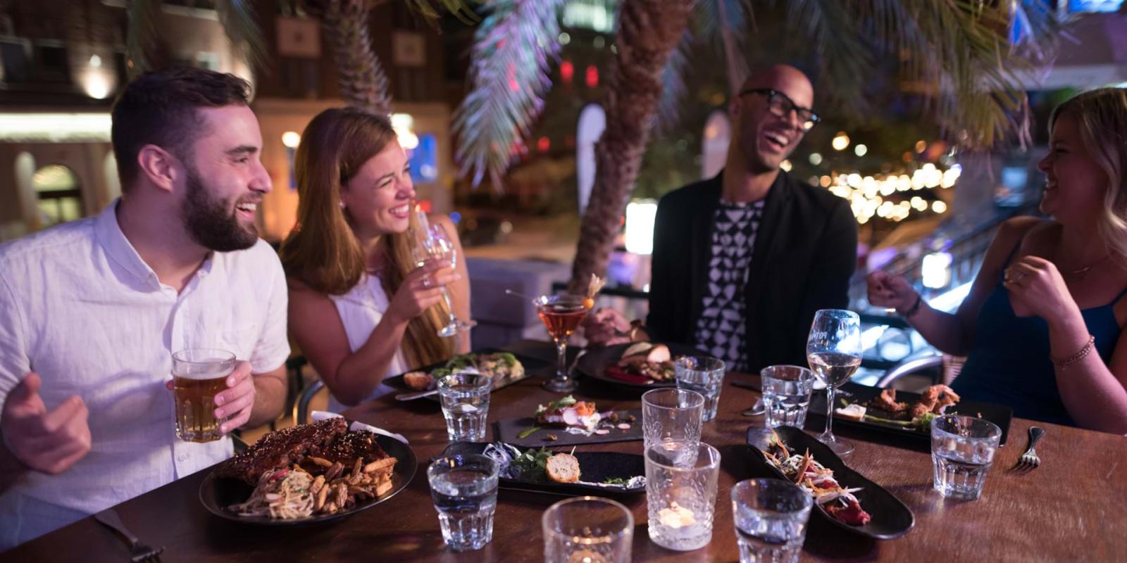 Souper entre amis sur une terrasse extérieure d'un restaurant sur Grande Allée en début de soirée. 